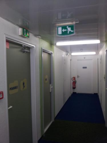 a hallway of a subway train with a sign on the ceiling at ibis Budget Gennevilliers Asnieres in Gennevilliers