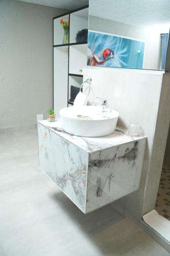 La salle de bains est pourvue d'un lavabo blanc et d'un miroir. dans l'établissement Jose Guesthouse, à Kempton Park
