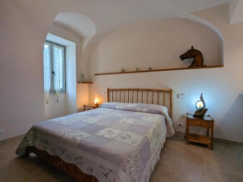 ein Schlafzimmer mit einem Bett und einem Pferd auf einem Regal in der Unterkunft Le Due Macine in Ventimiglia