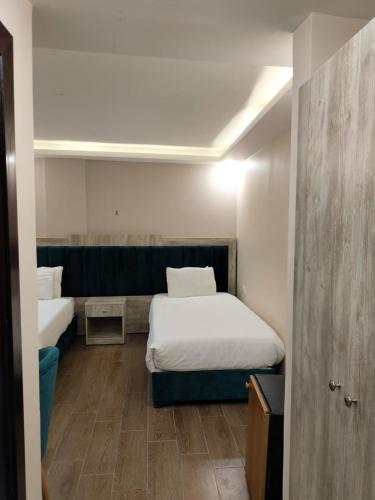 um pequeno quarto com duas camas e uma porta em Old Street Apartment em Wadi Musa