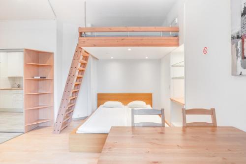 ein Schlafzimmer mit einem Etagenbett, einem Tisch und Stühlen in der Unterkunft Orchid&Sakura studios Kamppi in Helsinki