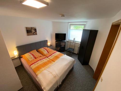 - une chambre avec un lit et une télévision dans l'établissement Ferienwohnung Witzig Inh Rita Weitmann, à Ingelheim-sur-le-Rhin