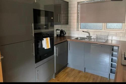 a kitchen with stainless steel appliances and a sink at HU1 Stylish Cozy Central Apartment WIFI H3 in Hull