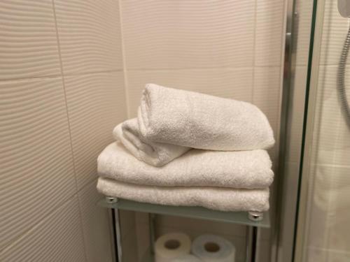 a pile of towels on a shelf in a bathroom at Klimatyczny apartament Romek 5 minut od Krupówek in Zakopane