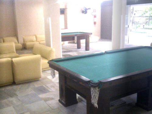 a living room with a pool table and a couch at Apartamento Cote d'Azur Enseada in Guarujá