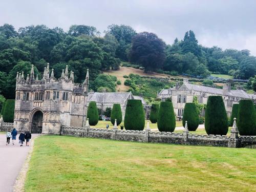 un viejo castillo con gente caminando delante de él en Bracken's Retreat, en Lostwithiel