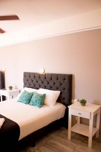 a bedroom with a large bed with blue pillows at Hotel Terrazas by CPH in Villa Carlos Paz