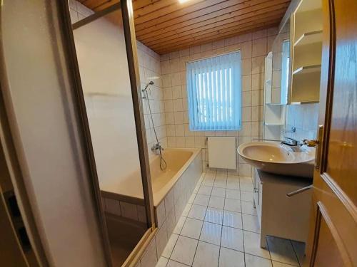 ein Badezimmer mit Badewanne, Waschbecken und Badewanne Tubermottermott in der Unterkunft Appartement Ariane in Frastanz