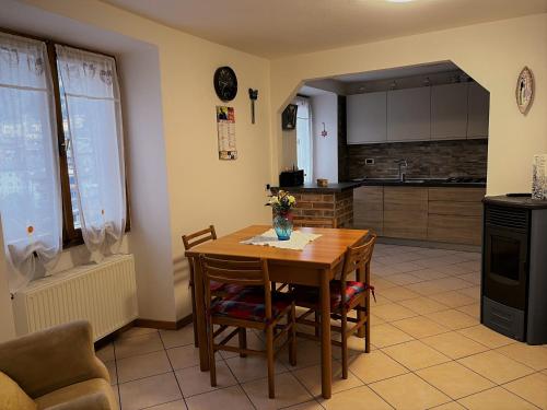 a kitchen with a wooden table with chairs and a table at Casa Alexandra in Drena