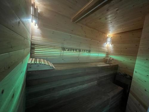 a sauna with wooden walls and a green light at El BURGO DE OSMA ALOJAMIENTO RURAL VILLA BAGH in El Burgo de Osma