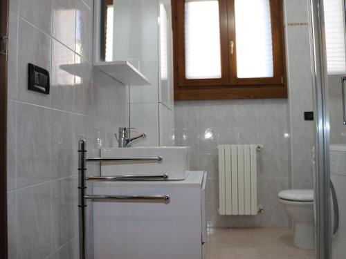 bagno bianco con lavandino e servizi igienici di Holiday apartment in Lazise, swimming pool and balcony overlooking the lake a Lazise