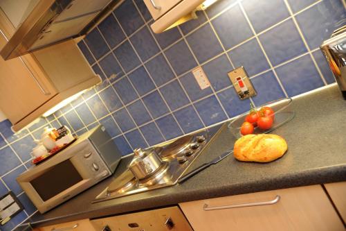 a kitchen counter with a sink and some tomatoes at PREMIER SUITES Bristol Redcliffe in Bristol
