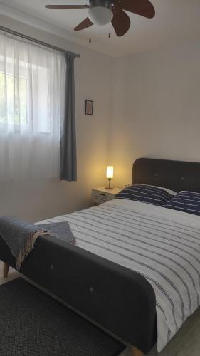 1 dormitorio con 1 cama grande y ventilador de techo en Apartment Loparina, en Nerezine