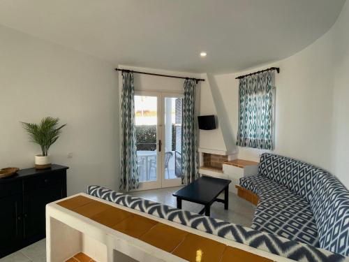 a living room with a couch and a table at Apartamentos Mar a mar in Cala en Forcat