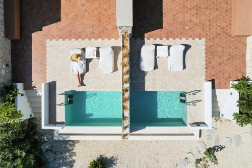 una vista aérea de una mujer parada junto a una piscina en Onar Beach Houses, en Amoopi