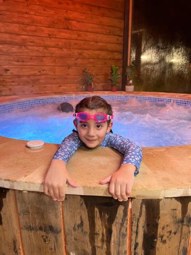 a young boy wearing a pair of pink glasses in a swimming pool at El BURGO DE OSMA ALOJAMIENTO RURAL VILLA BAGH in El Burgo de Osma