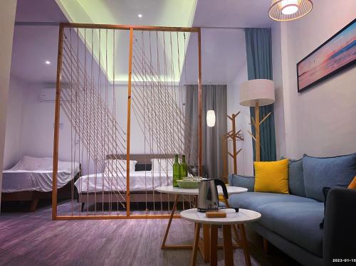 a living room with a blue couch and a bedroom at Bohol Sojourn Villa Alona in Panglao