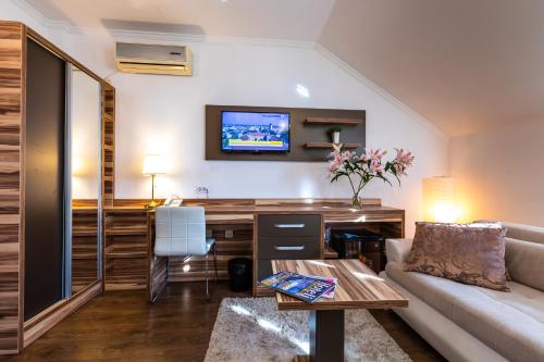 a living room with a couch and a desk at Garni Hotel Royal Crown in Subotica