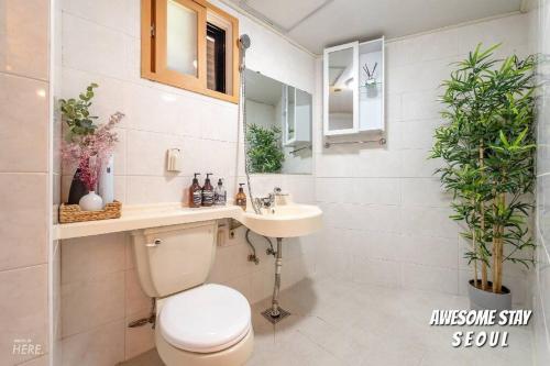 a bathroom with a toilet and a sink and a mirror at Lazo House in Seoul