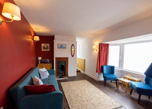 a living room with a blue couch and chairs at The Wave - 3 bed beach front home in Sheringham in Sheringham