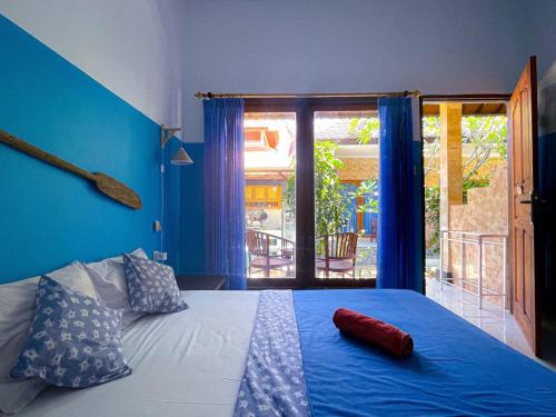 a blue bedroom with a large bed with blue walls at Pandan Wangi in Nusa Lembongan