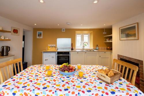 a kitchen with a table with a bowl of fruit on it at The Wave - 3 bed beach front home in Sheringham in Sheringham