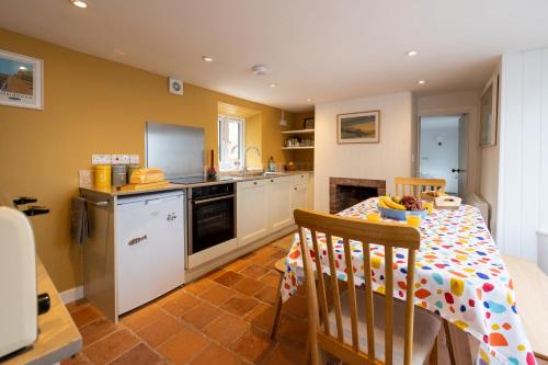 a kitchen with a table and a kitchen with a stove at The Wave - 3 bed beach front home in Sheringham in Sheringham