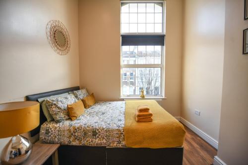 a small bedroom with a bed and a window at Charming 2-Bedroom flat in Shepherd's Bush in London