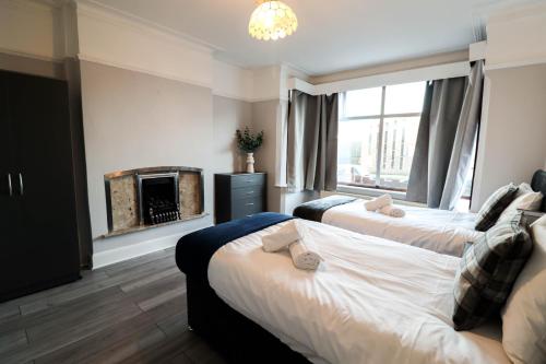 2 camas en una habitación con chimenea en Modern Contractor Housing - FREE WiFi and parking! en Luton