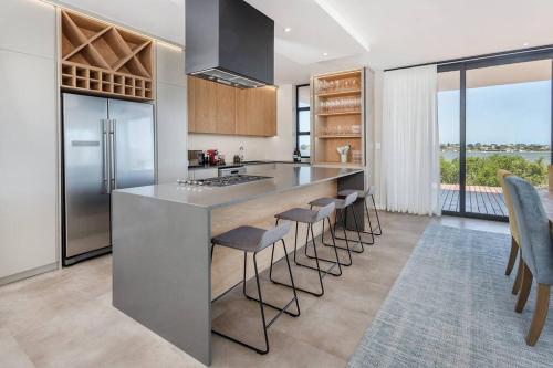 a kitchen with a large island with bar stools at Benguela Cove - Coastal Retreat in Hermanus