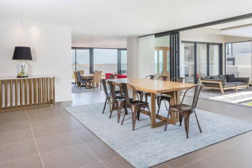 a dining room with a wooden table and chairs at Benguela Cove - Coastal Retreat in Hermanus