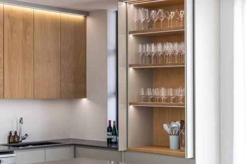 a kitchen with wine glasses in a cabinet at Benguela Cove - Coastal Retreat in Hermanus