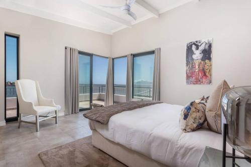 a bedroom with a bed and views of the ocean at Coastal Retreat, wine and relax in Hermanus