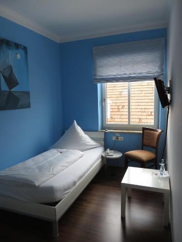 a blue room with a bed and a chair at Hotel Lutz in Rain