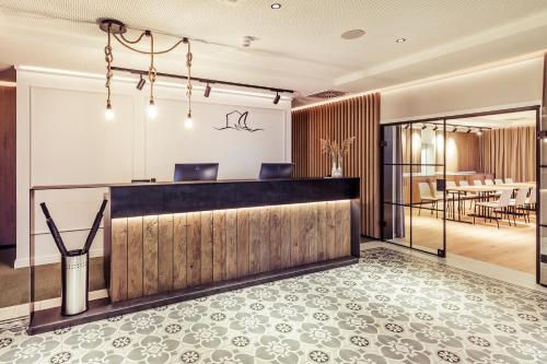a hotel lobby with a reception desk and a dining area at Hafenhotel zu Putbus in Putbus