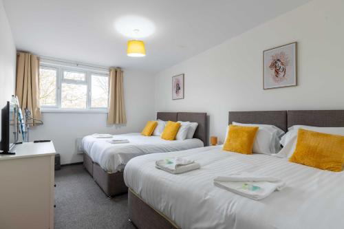 1 dormitorio con 2 camas y TV. en The Eldern - Spacious, Netflix, free Parking, close to A1 en Peterborough