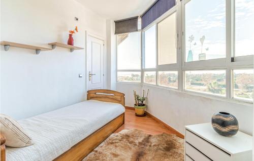 1 dormitorio con 1 cama con paredes y ventanas blancas en Lovely Apartment In Estepona With House A Mountain View, en Estepona