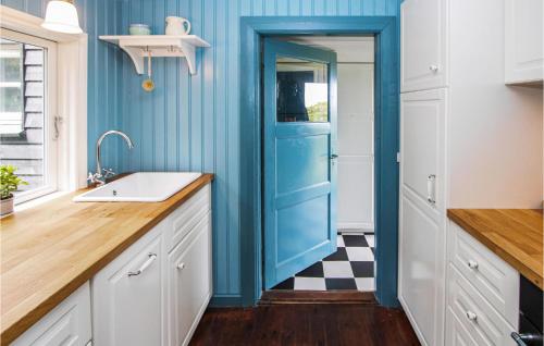 a blue door in a kitchen with a checkered floor at 2 Bedroom Cozy Home In Samsø in Nordby