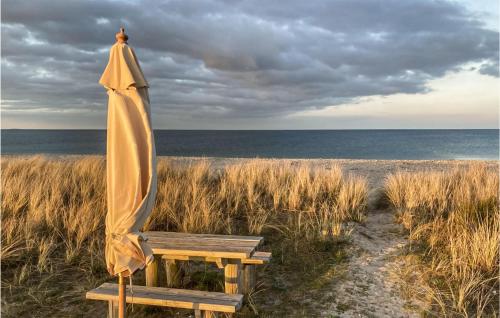 an umbrella and a bench on the beach at 2 Bedroom Cozy Home In Samsø in Nordby
