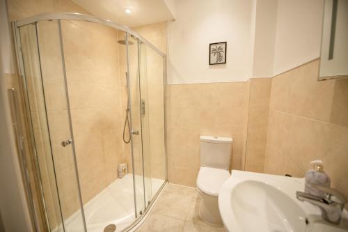 a bathroom with a shower and a toilet and a sink at Charming 2-Bedroom flat in Shepherd's Bush in London