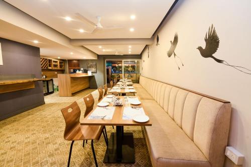 a long dining room with long tables and benches at SAFARI QUEST in Mysore