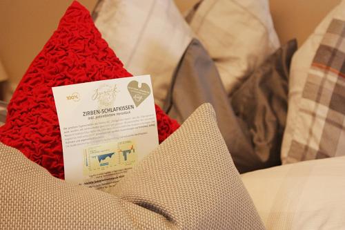 a red hat sitting on top of a bed at Boutique-Pension Jägerwirt in Scheffau am Wilden Kaiser