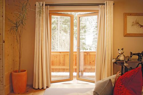 a living room with a sliding glass door at Boutique-Pension Jägerwirt in Scheffau am Wilden Kaiser