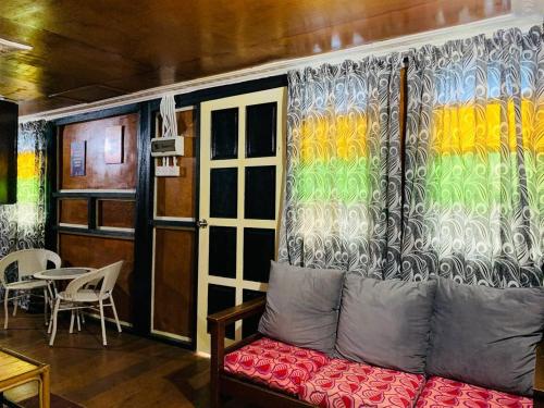a living room with a couch and a colorful curtain at MOSS HEDERA HIDE CHALET in Melaka