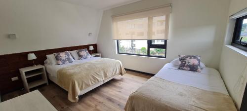 ein Schlafzimmer mit zwei Betten und einem Fenster in der Unterkunft Patagonia Route Apartments in Puerto Varas