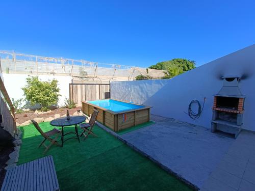 un pequeño patio con mesa y piscina en La casita de Aitor; campo y playa en el Médano, en El Médano