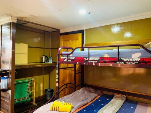 a bedroom with two bunk beds and a kitchen at MOSS HEDERA HIDE CHALET in Melaka