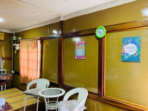 a room with a table and chairs and a clock on the wall at MOSS HEDERA HIDE CHALET in Melaka