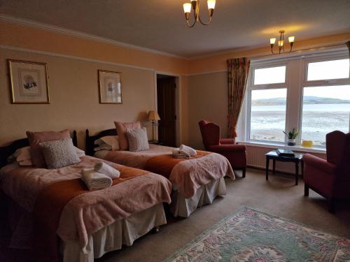 a hotel room with two beds and a window at Balcary Bay Country House Hotel in Auchencairn