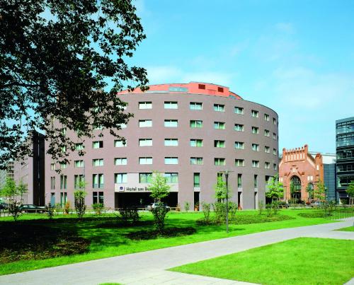 a large white building with a red roof at Hotel am Borsigturm in Berlin